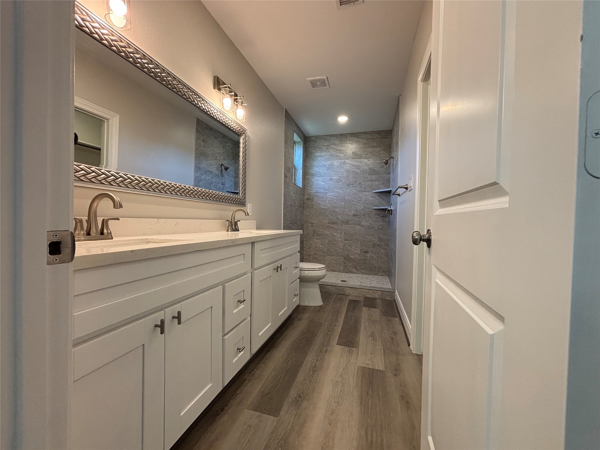 504 Nursery Road, Unit 1108 The Woodlands, TX 77380 - Photo 17 of 25 a spacious bathroom with a double vanity sink a toilet and a mirror