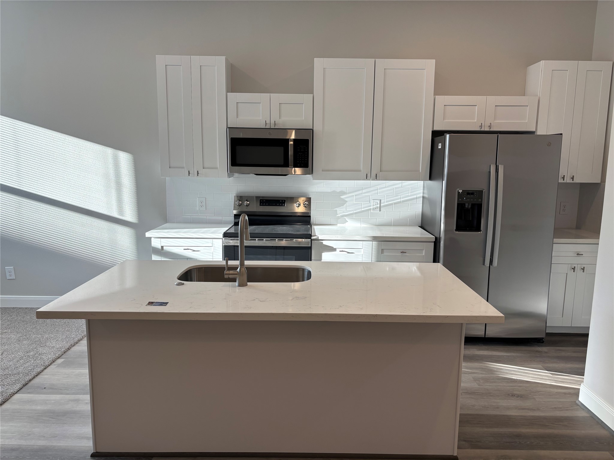 504 Nursery Road, Unit 1108 The Woodlands, TX 77380 - Photo 19 of 25 a kitchen with stainless steel appliances a refrigerator a stove a sink and white cabinets