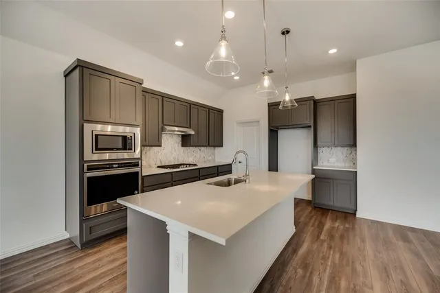 a kitchen with a refrigerator a sink and a oven