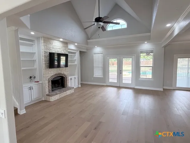 a view of an empty room with a fireplace and a window