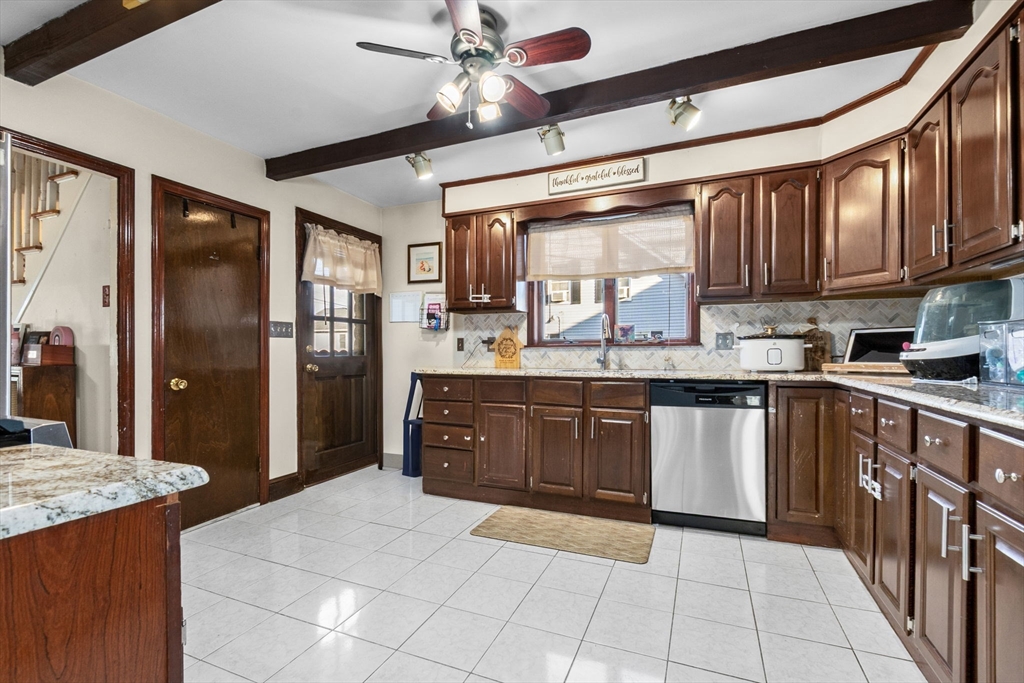 65 Poplar Street Gloucester, MA 01930 - Photo 10 of 23 a kitchen with stainless steel appliances granite countertop a refrigerator a sink dishwasher a stove with wooden cabinets