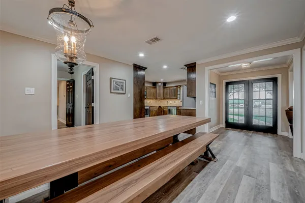 a large kitchen with stainless steel appliances a large counter top a stove and a refrigerator with wooden floor