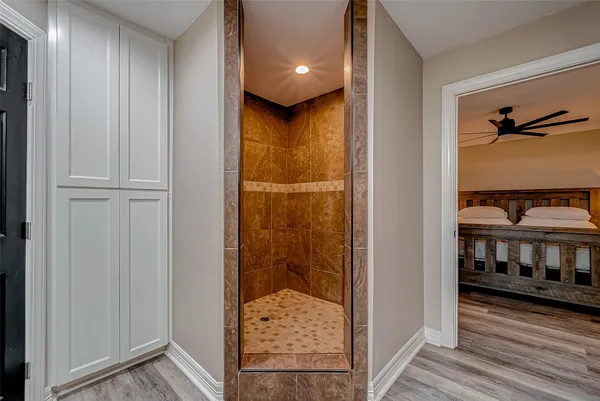 a bedroom with a bed a chandelier and a chair