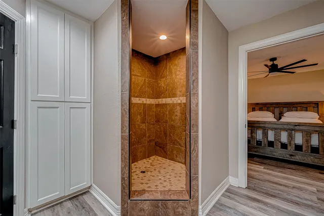 a bedroom with a bed a chandelier and a chair