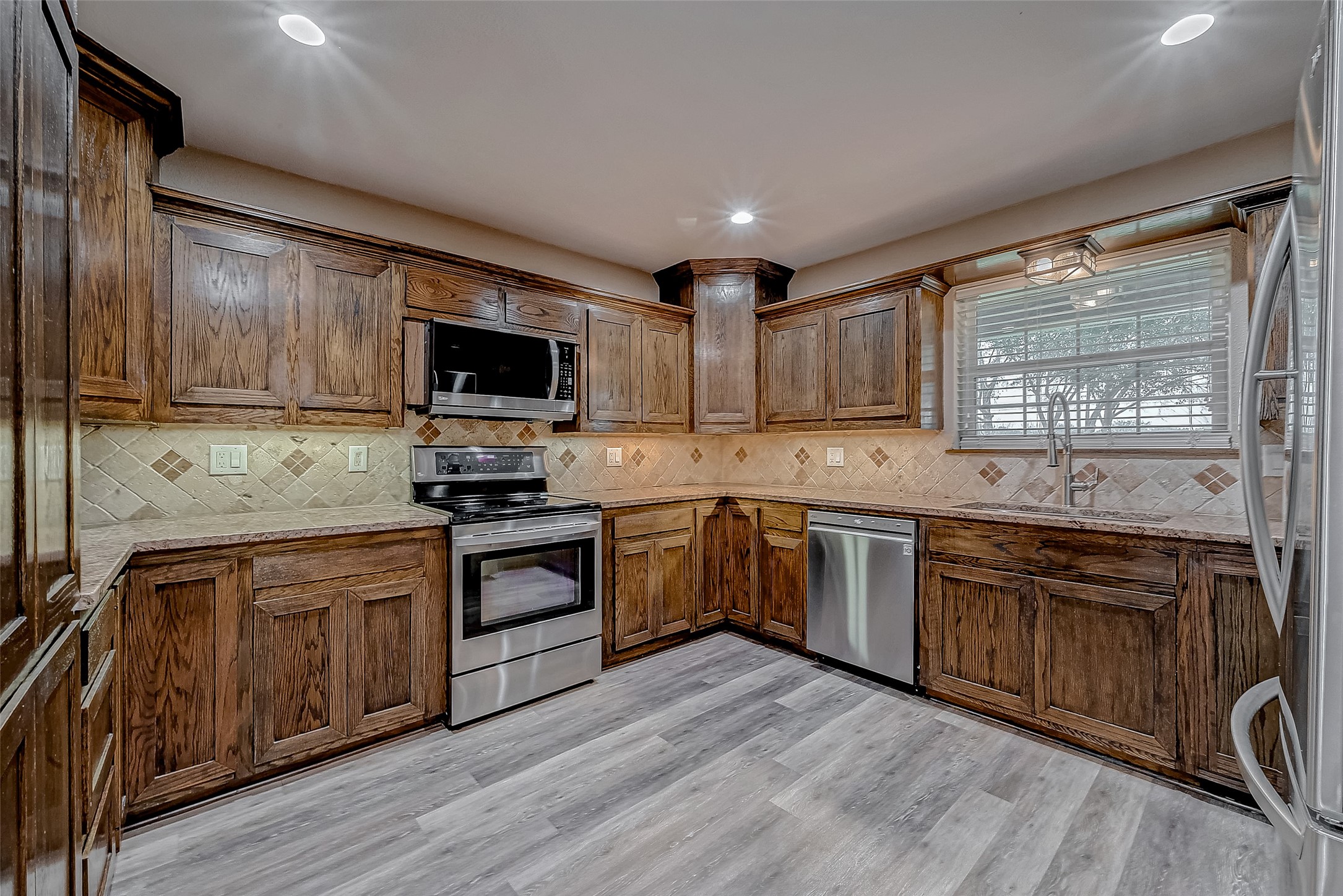 3819 Cottonwood School Road Rosenberg, TX 77471 - Photo 9 of 37 a kitchen with granite countertop wooden cabinets and a stove top oven
