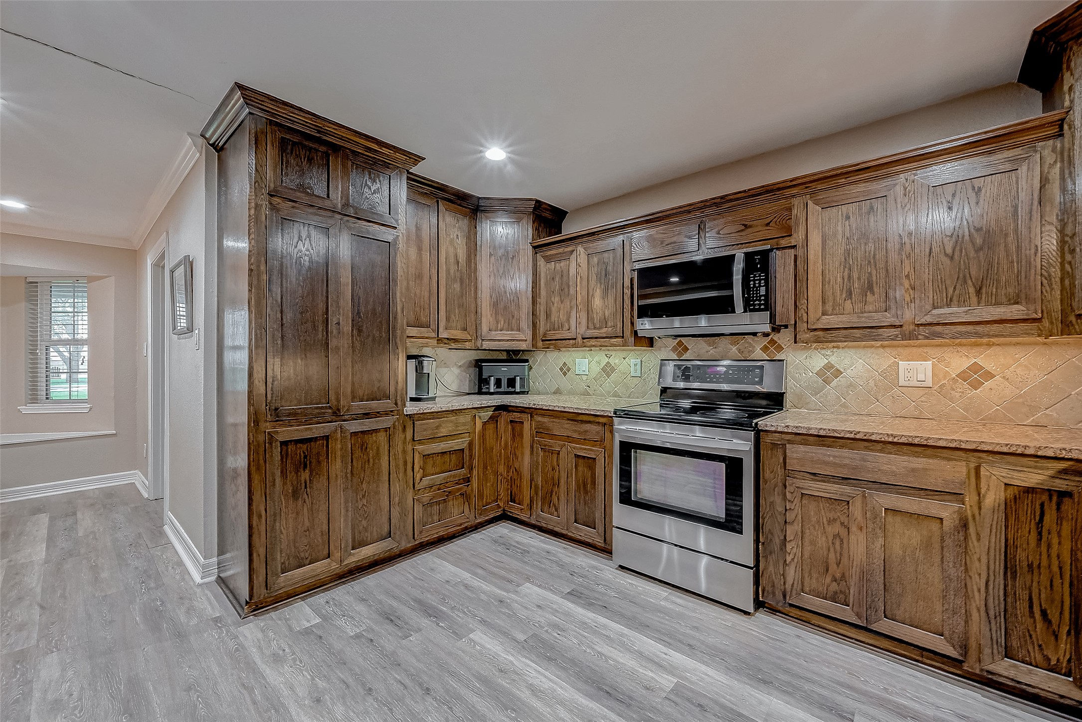 3819 Cottonwood School Road Rosenberg, TX 77471 - Photo 10 of 37 a kitchen with stainless steel appliances granite countertop a stove a sink dishwasher a refrigerator and a microwave oven with wooden floor