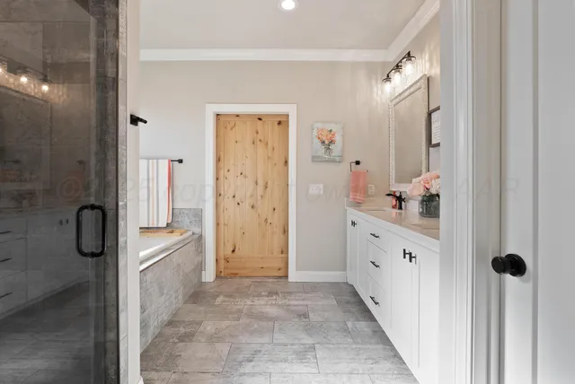 a bathroom with a granite countertop sink a mirror a vanity and a shower