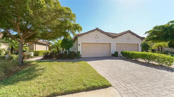 a view of a house with a yard and large tree