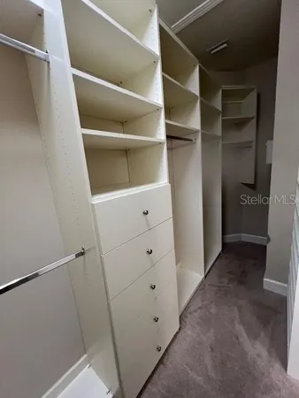 a view of walk in closet with empty racks