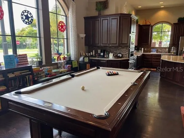 a kitchen with kitchen island granite countertop a sink cabinets and wooden floor