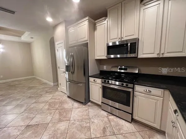a kitchen with stainless steel appliances granite countertop a stove a refrigerator and a microwave