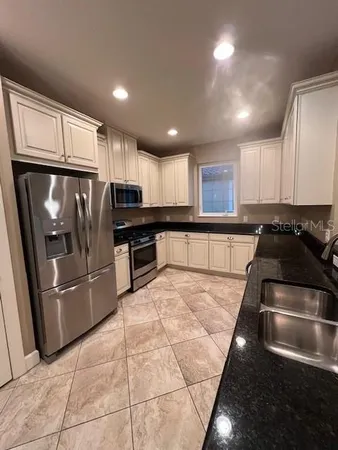 a kitchen with stainless steel appliances granite countertop a refrigerator and a stove top oven