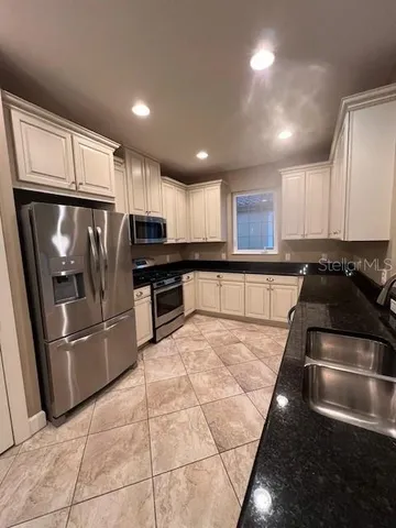 a kitchen with stainless steel appliances granite countertop a refrigerator and a stove top oven