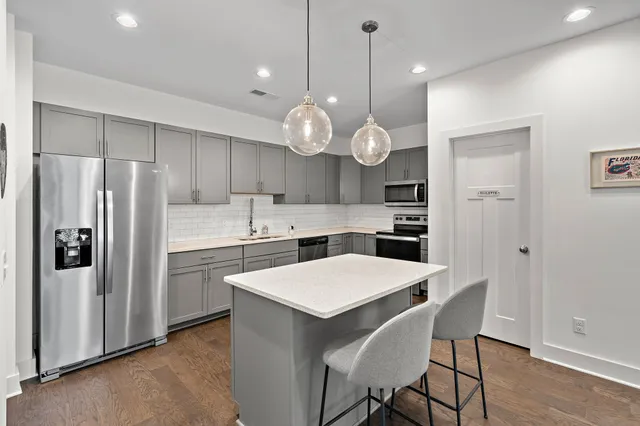 a kitchen with stainless steel appliances a refrigerator a stove a sink and a refrigerator