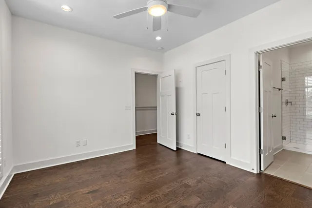 an empty room with a ceiling fan and a bathroom