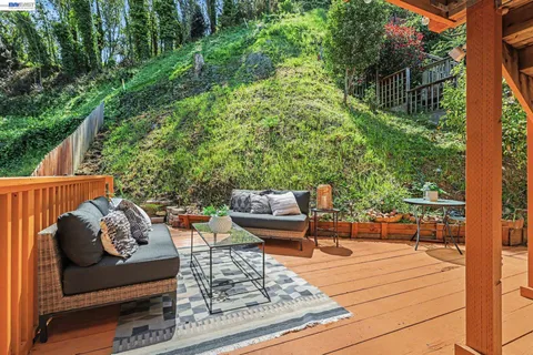 a balcony with wooden floor and outdoor seating