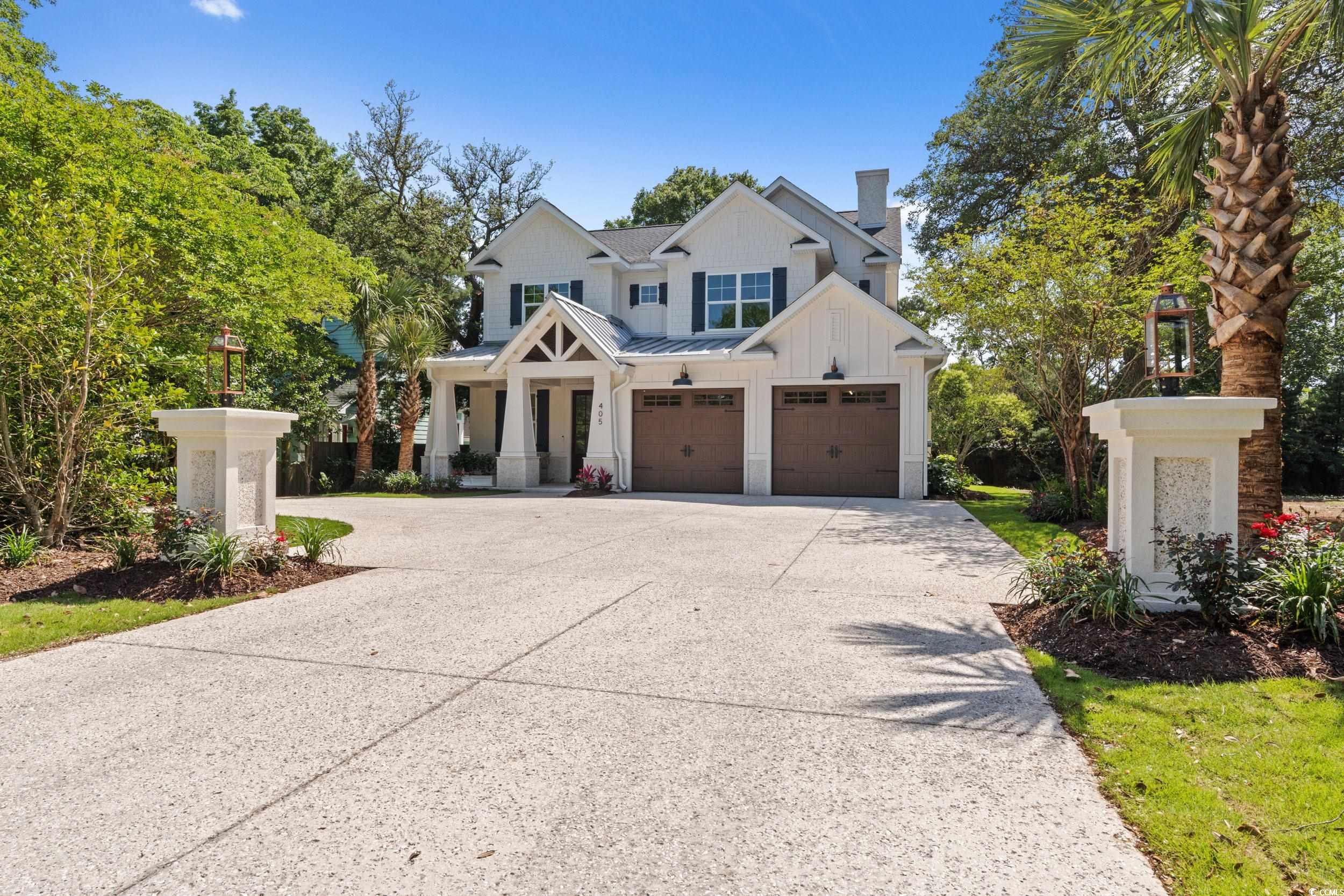 405 North Highland Way Myrtle Beach, SC 29572 - Photo 2 of 40 View of front of house featuring board and batten siding, a garage, driveway, a standing seam roof, and a chimney