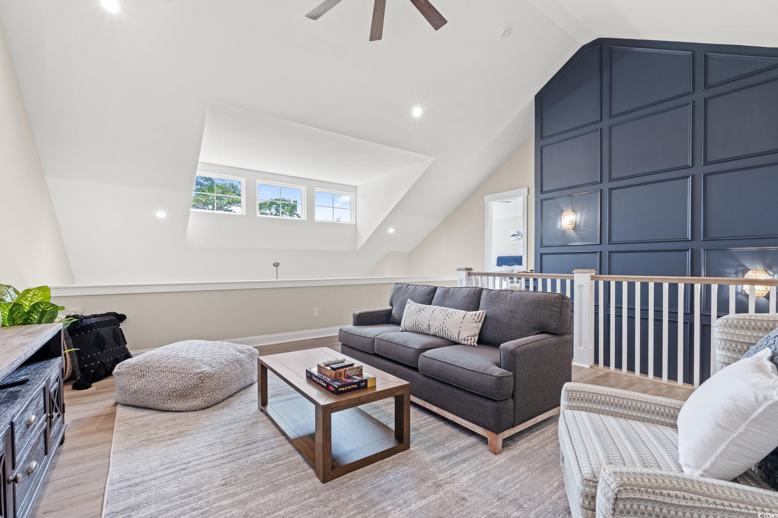 405 North Highland Way Myrtle Beach, SC 29572 - Photo 25 of 40 Living area with vaulted ceiling, ceiling fan, a decorative wall, and light wood-type flooring