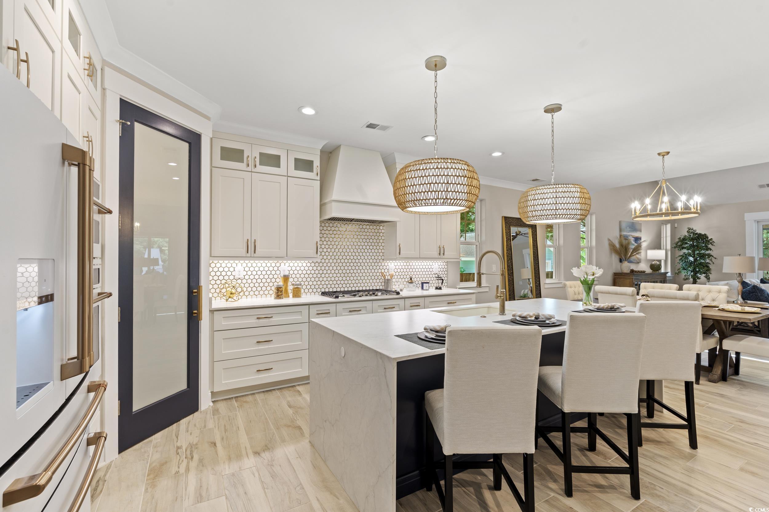 405 North Highland Way Myrtle Beach, SC 29572 - Photo 8 of 40 Kitchen featuring a sink, stainless steel gas stovetop, premium range hood, white fridge with ice dispenser, and a breakfast bar