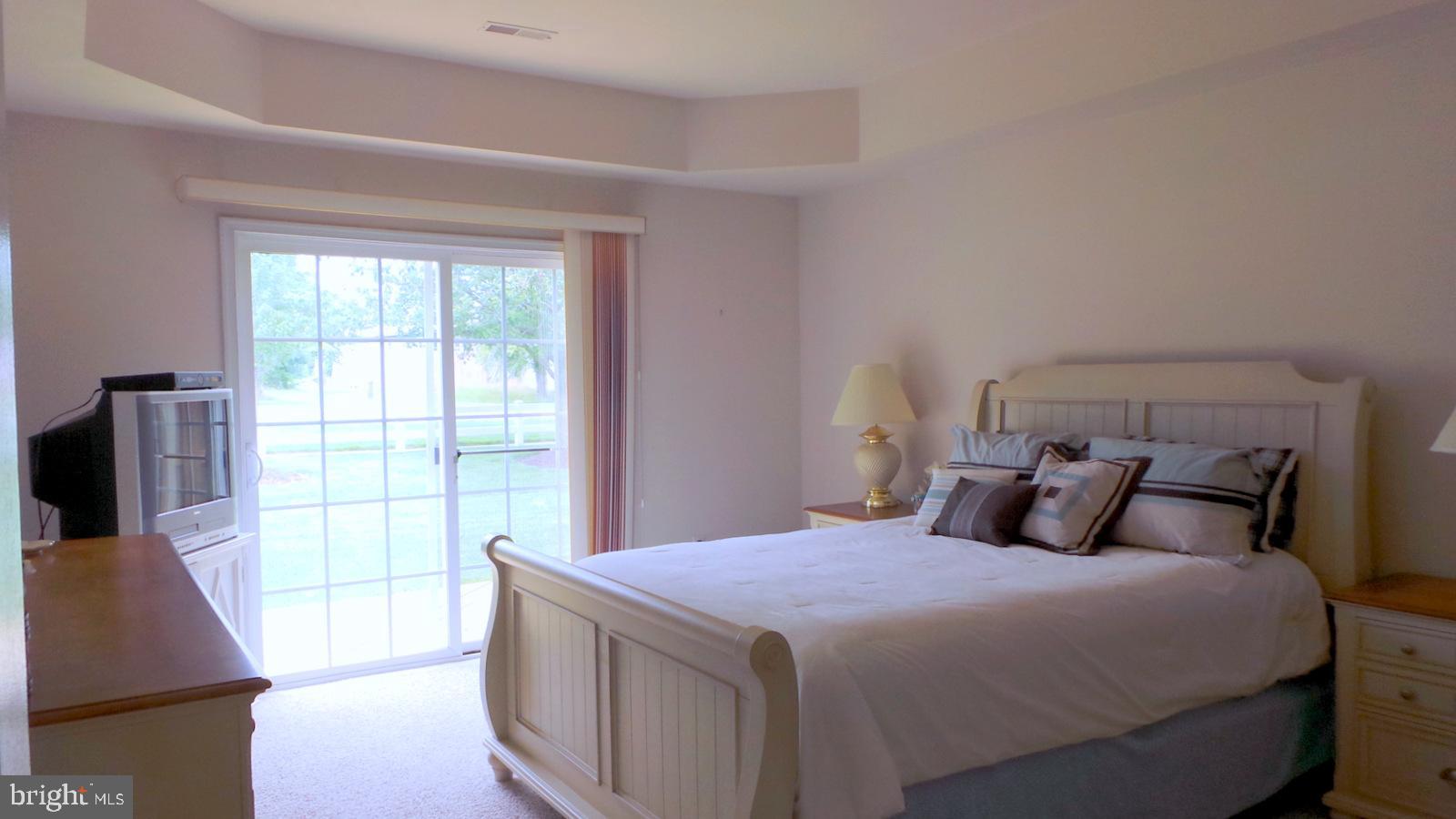 508 Summerset Court, Unit 33 Solomons, MD 20629 - Photo 15 of 36 a bedroom with a large bed and a flat tv screen on dresser