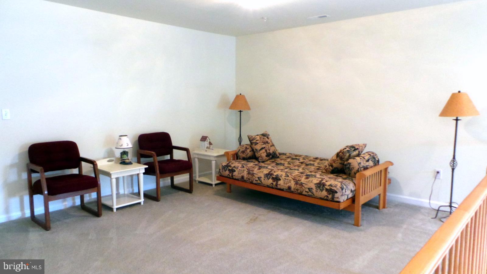 508 Summerset Court, Unit 33 Solomons, MD 20629 - Photo 21 of 36 a bedroom with furniture and a chair