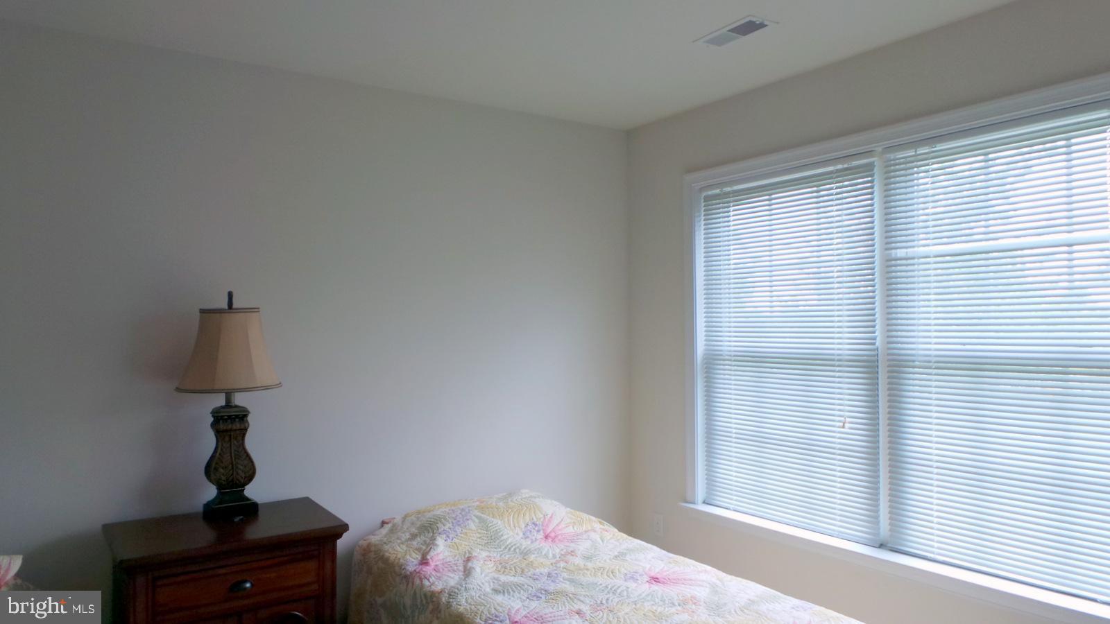 508 Summerset Court, Unit 33 Solomons, MD 20629 - Photo 27 of 36 a bedroom with a bed window and a lamp