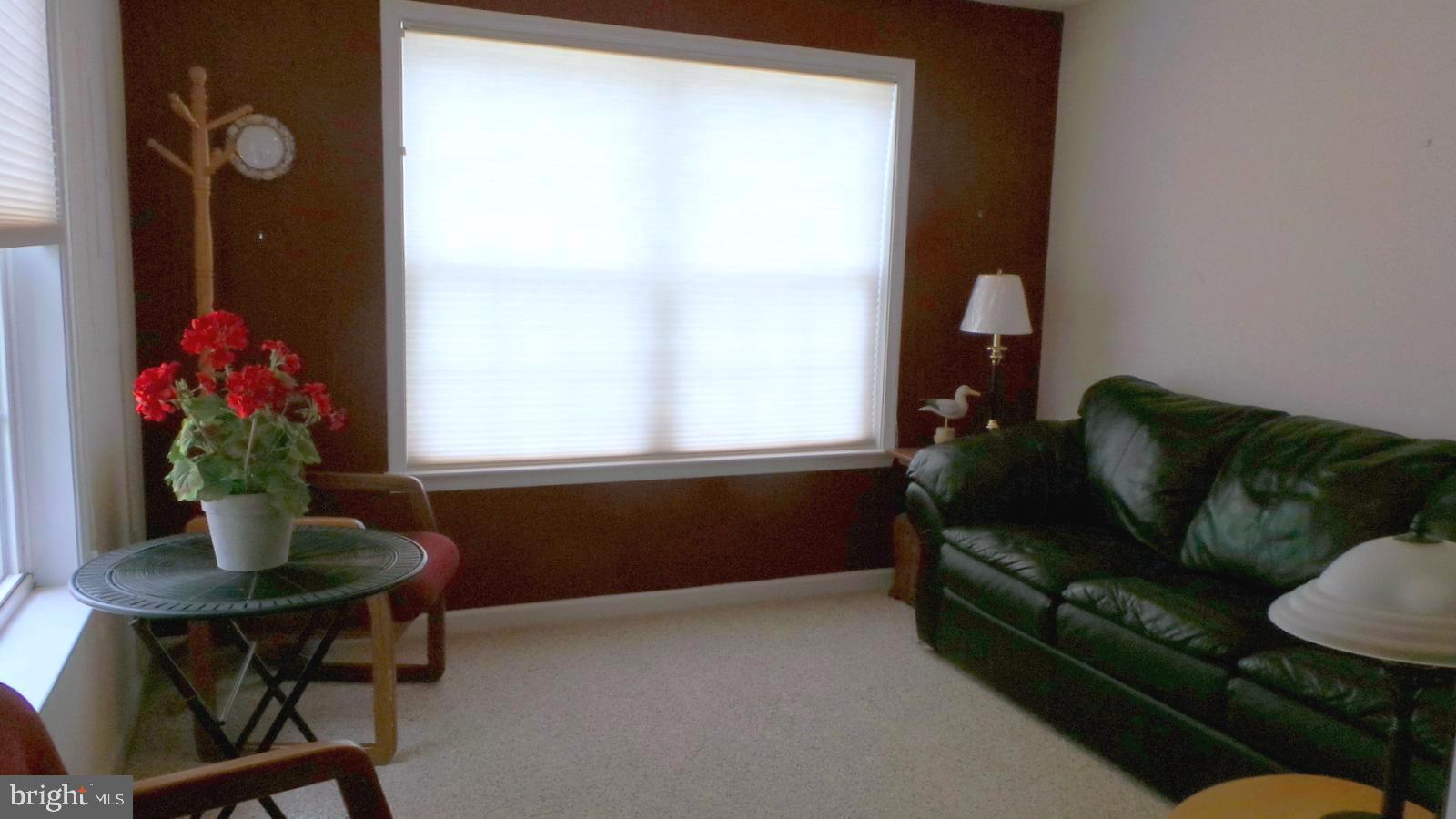 508 Summerset Court, Unit 33 Solomons, MD 20629 - Photo 7 of 36 a living room with furniture and flowers