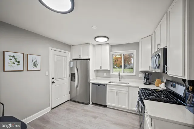 a kitchen with a refrigerator a sink and cabinets