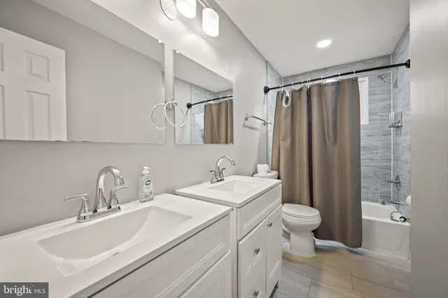 a bathroom with a sink toilet double vanity and shower