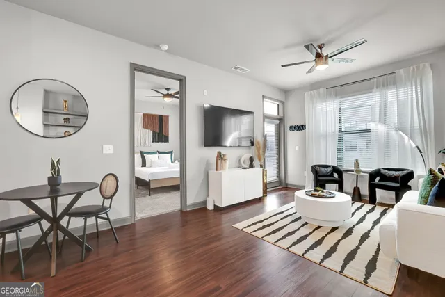 a living room with furniture a wooden floor and a chandelier