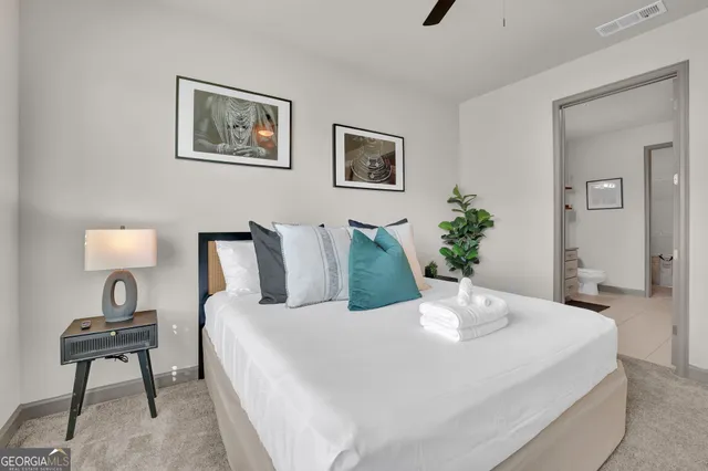 a bedroom with a bed and a painting on the wall