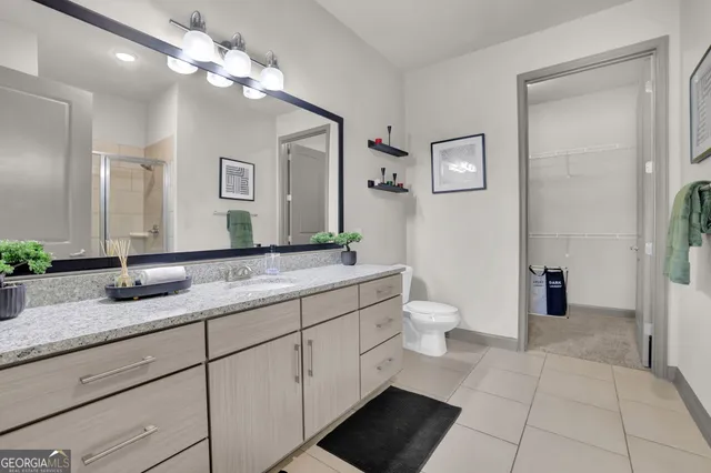 a bathroom with a granite countertop sink a toilet and a mirror