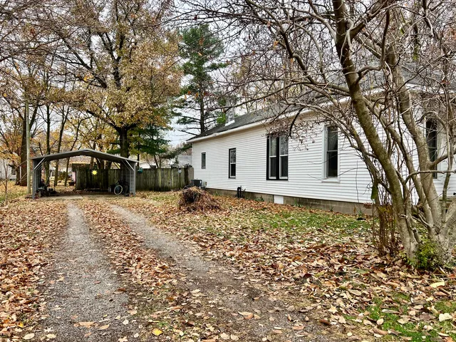 a front view of a house with a yard covered with snow in front of house