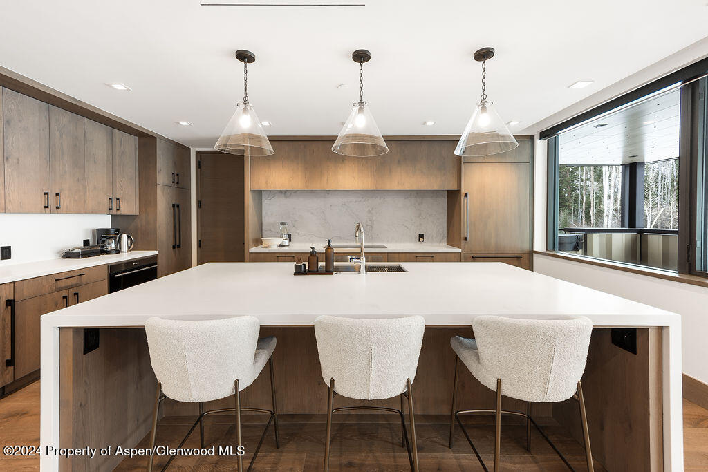 180 Wood Road, Unit 302 Snowmass Village, CO 81615 - Photo 12 of 43 a large white kitchen with a dining table and chairs