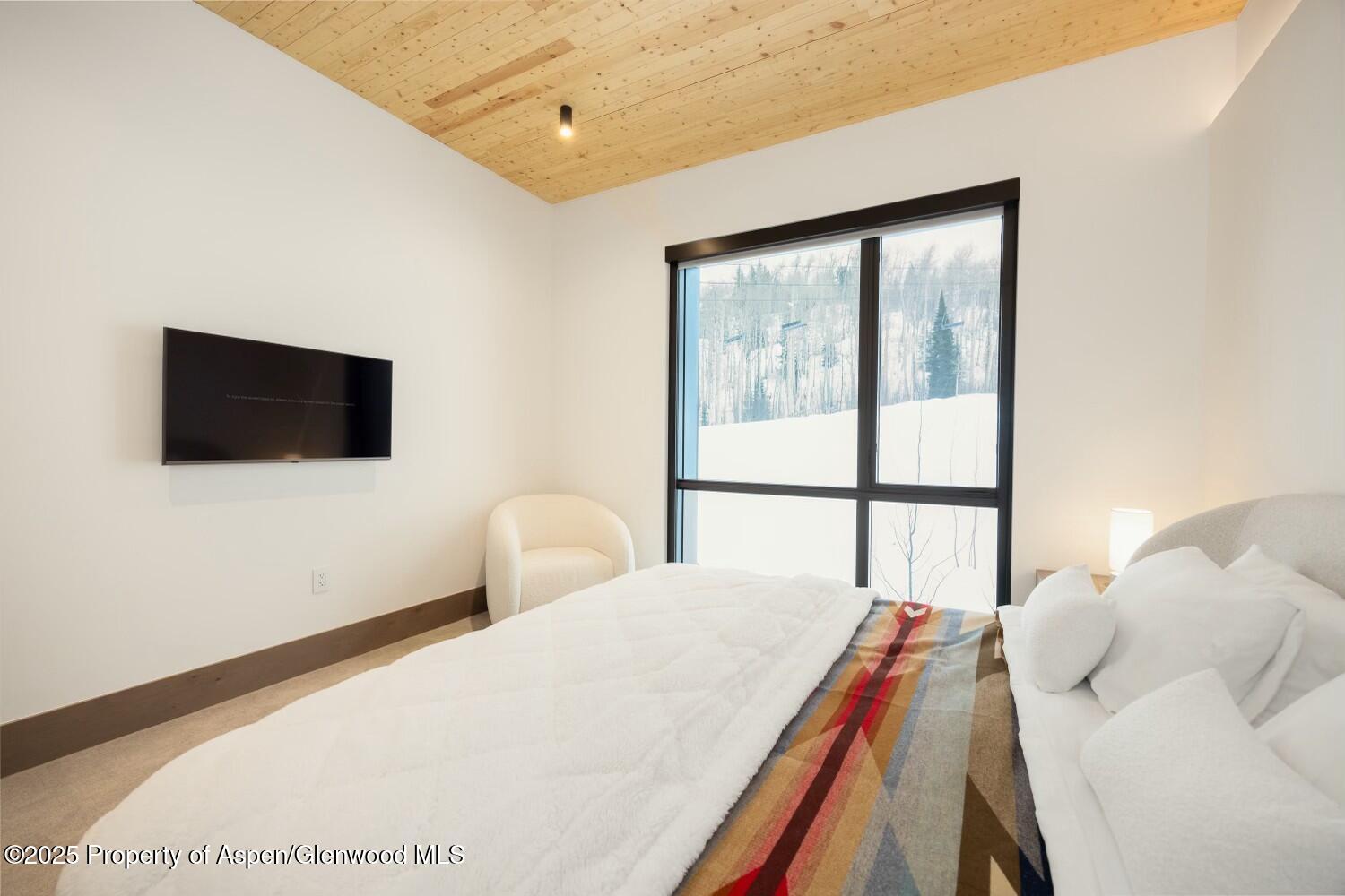 180 Wood Road, Unit 302 Snowmass Village, CO 81615 - Photo 15 of 43 a bedroom with a bed and a flat screen tv