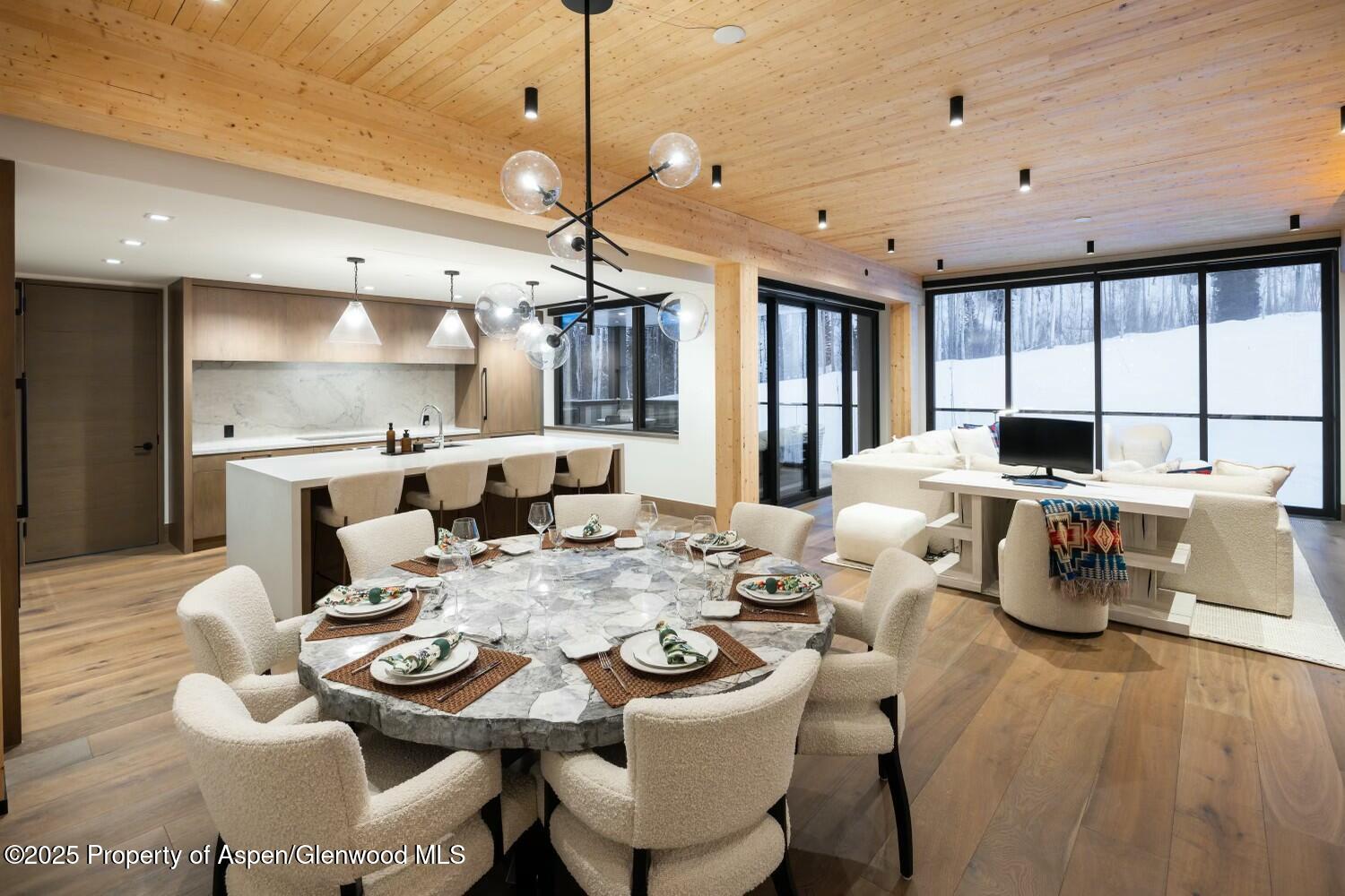 180 Wood Road, Unit 302 Snowmass Village, CO 81615 - Photo 2 of 43 a dining room with furniture a chandelier and wooden floor