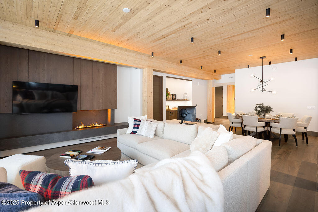 180 Wood Road, Unit 302 Snowmass Village, CO 81615 - Photo 5 of 43 a living room with furniture and a flat screen tv