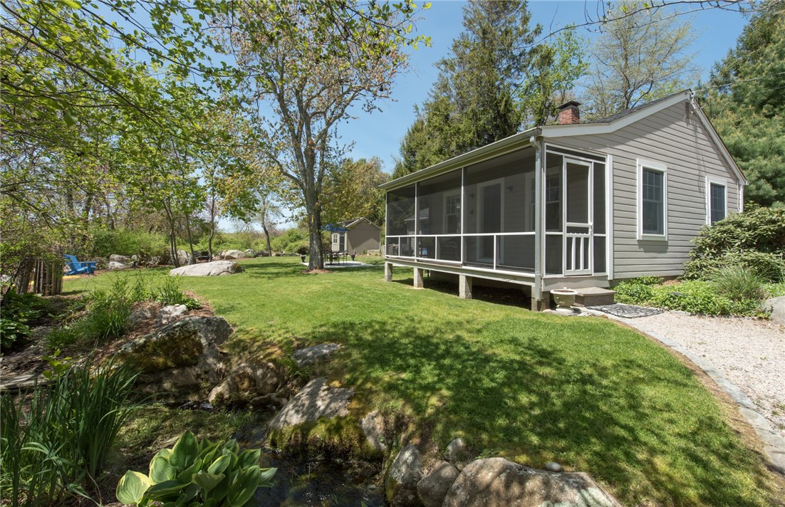 BEAUTIFUL ANGLE OF THE COTTAGE AND LANDSCAPED BROOK INTO THE PRIVATE BACKYARD.