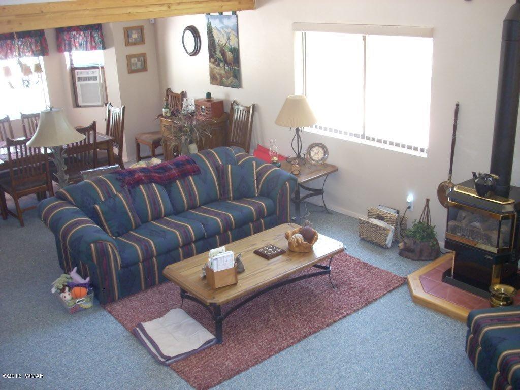2101 Chevelon Road Overgaard, AZ 85933 - Photo 23 of 45 a living room with furniture a window and a lamp