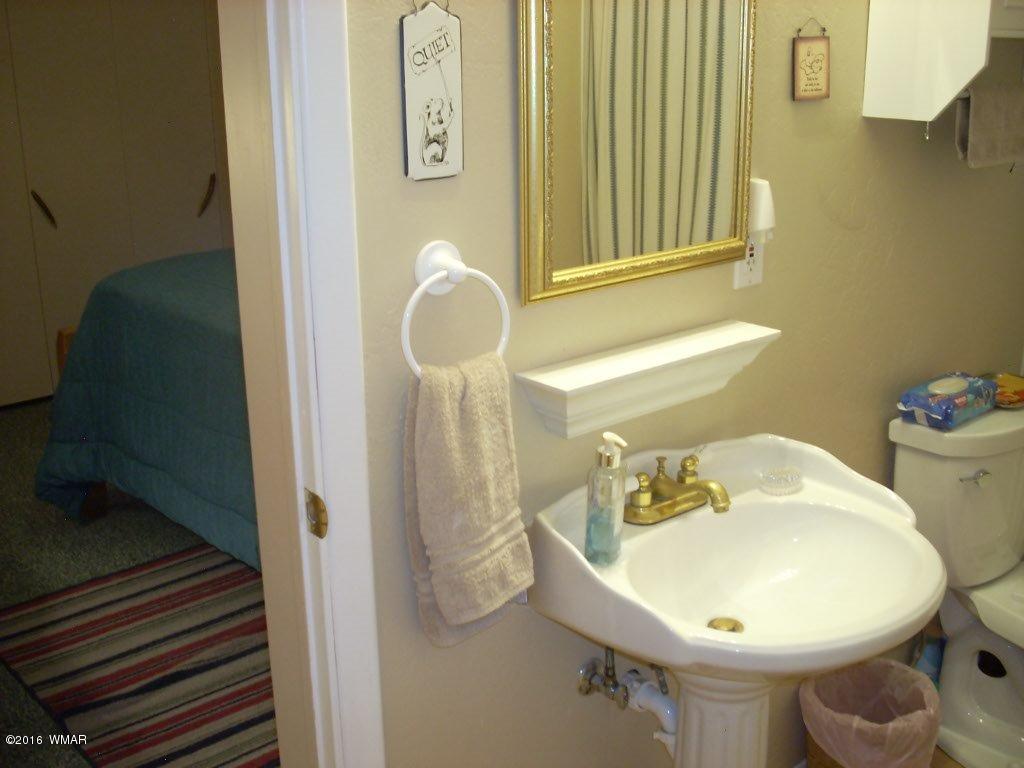 2101 Chevelon Road Overgaard, AZ 85933 - Photo 26 of 45 a bathroom with a sink mirror and toilet