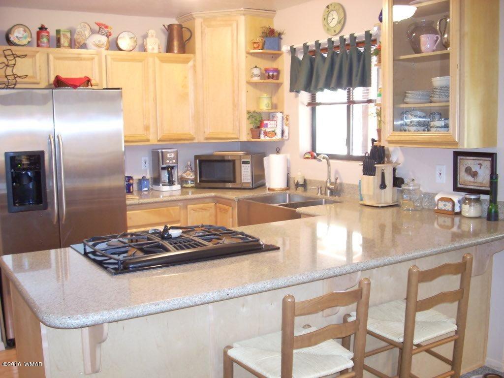 2101 Chevelon Road Overgaard, AZ 85933 - Photo 43 of 45 a kitchen with a stove a sink and a refrigerator