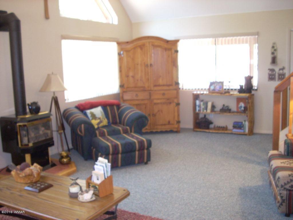 2101 Chevelon Road Overgaard, AZ 85933 - Photo 8 of 45 a living room with furniture fireplace and a large window