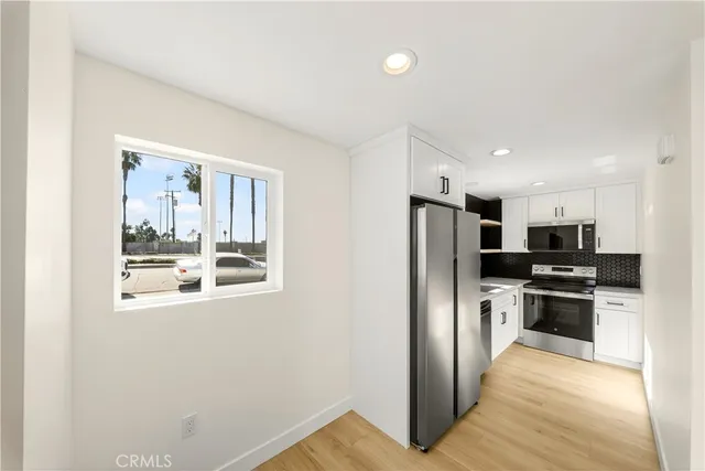 a kitchen with stainless steel appliances a refrigerator and a stove top oven