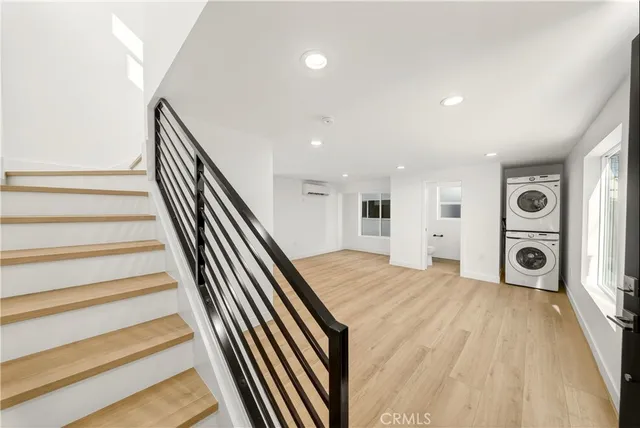 a view of a hallway with wooden floor and stairs
