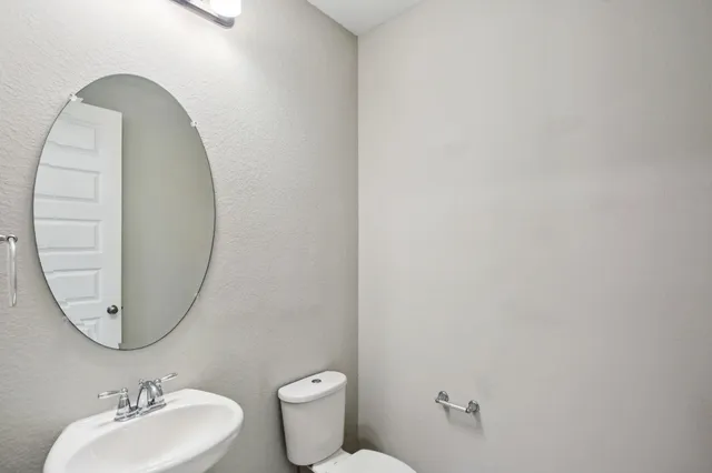a bathroom with a toilet sink and mirror