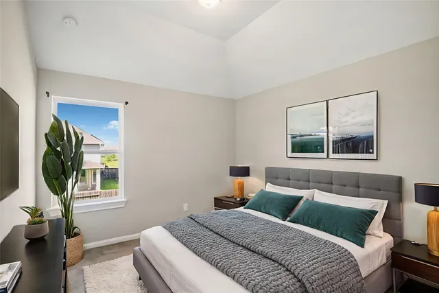 a bedroom with a bed and a potted plant