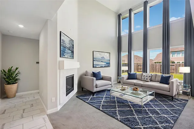 a living room with furniture a large window and a fireplace