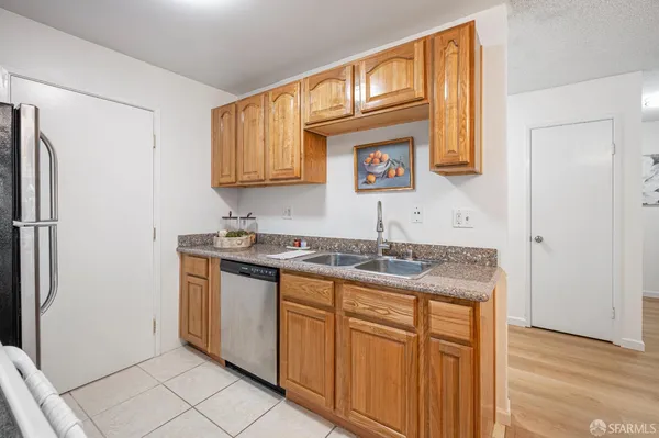 a kitchen with stainless steel appliances granite countertop a sink and a refrigerator