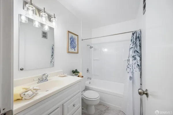 a bathroom with a bathtub shower sink vanity and toilet