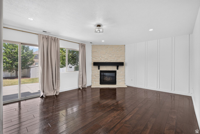 2223 North Pointe Meadow Loop Lehi, UT 84048 - Photo 17 of 56 Spacious interior featuring dark wood-finish flooring, a stone-clad fireplace with a dark mantel, and recessed lighting